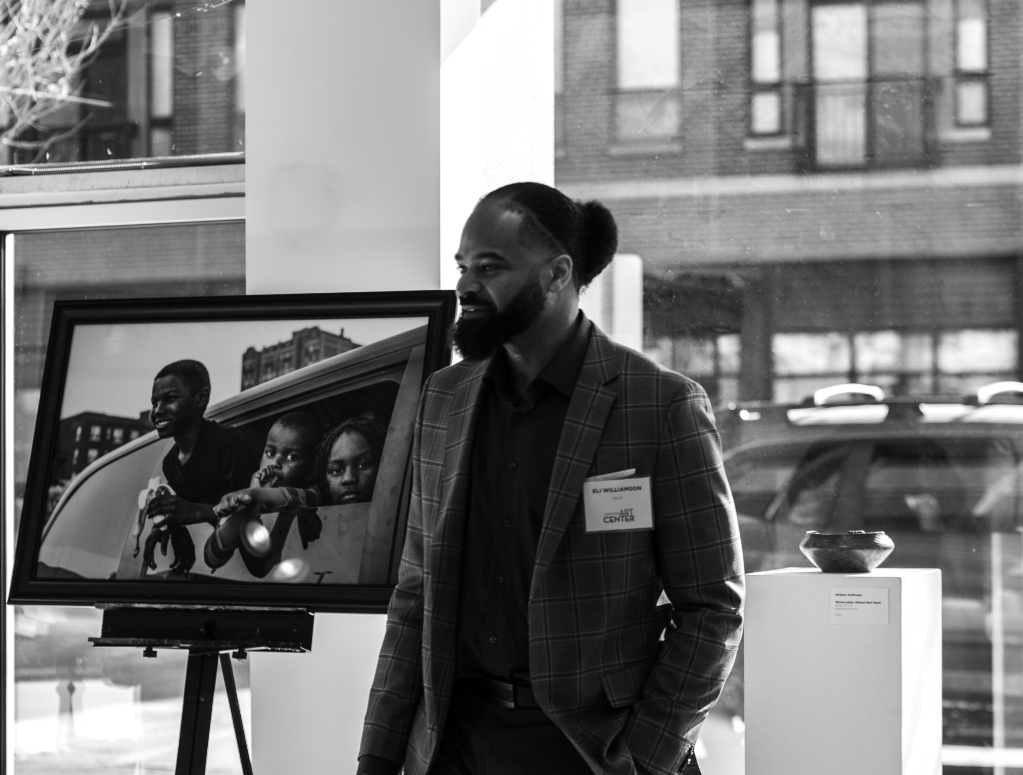 eli williamson beside a framed photograph at Evanston Art Center